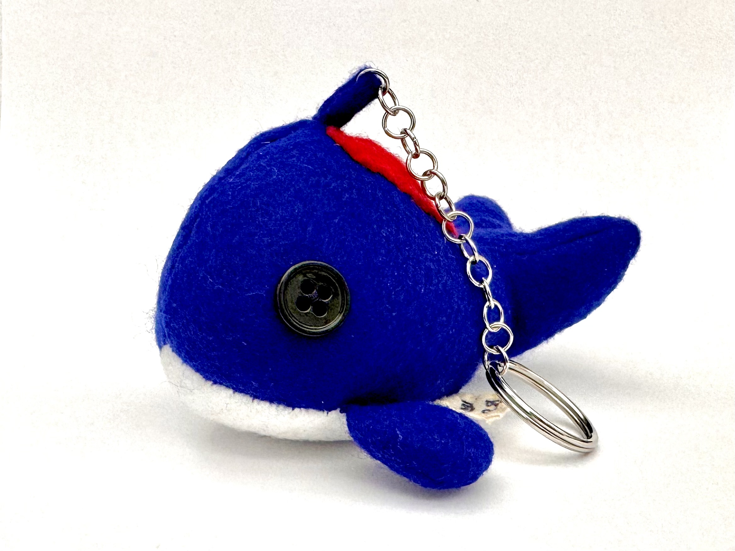 An individual keychain style Heart Whale which has a red heart patch.